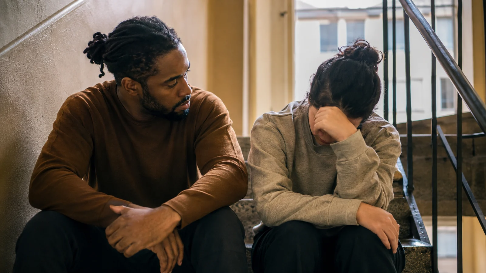 A calm man listening to a distressed friend in a quiet setting.
